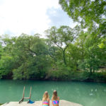 Girls sitting in front of Geronimo Creek Seguin Texas