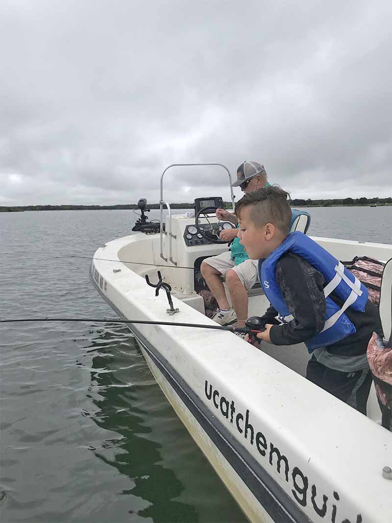 Best Guided Fishing Trips in Texas - young boy fishing from a boat